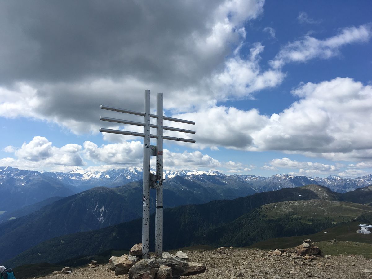 Doppelkreuz auf einem Gipfel über den Alpen