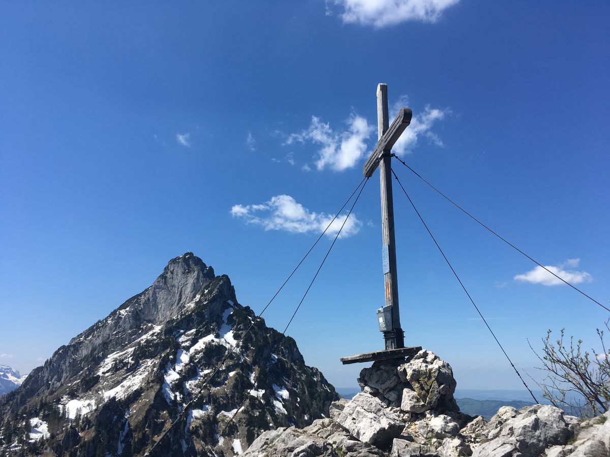 Gipfelkreuz vor einer schneebedeckten Felsspitze