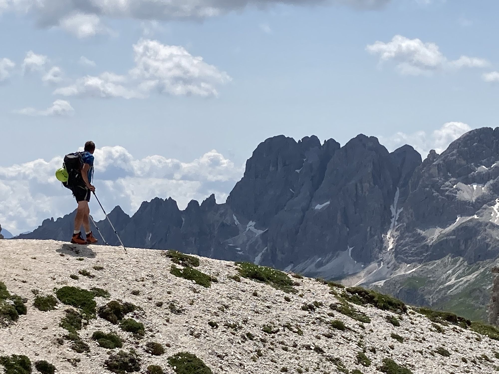 Othmar Schuster mit Rucksack auf einem Grat vor den Dolomiten